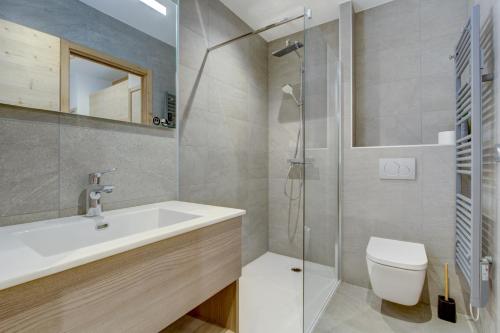 une salle de bain avec un lavabo, des toilettes et une douche dans l'établissement Echo du Pleney A003, à Morzine
