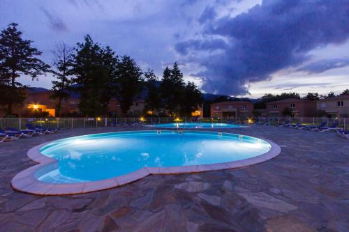 - une grande piscine dans une cour la nuit dans l'établissement Villa de Mélody 17, à Moriani-Plage