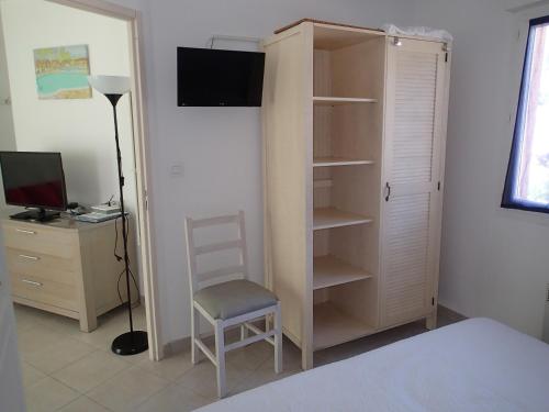 - une chambre avec un placard, un bureau et une chaise dans l'établissement Villa de Mélody 17, à Moriani-Plage