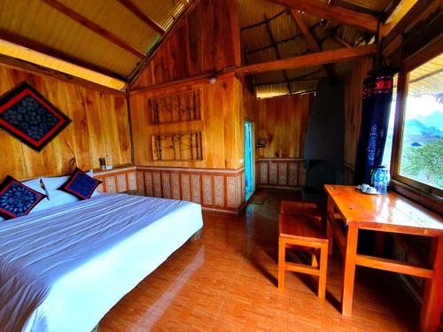 a bedroom with a bed and a desk in a room at Hoa Phong homestay Moc Chau in Mộc Châu
