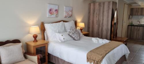 a bedroom with a large white bed and a chair at Private Guest Suite with 24hr Electricity, East London in East London