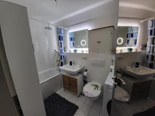 ein Badezimmer mit zwei Waschbecken, einem WC und einer Badewanne in der Unterkunft Happy Trails, Cosy One Room Garten Apartment in Oberau