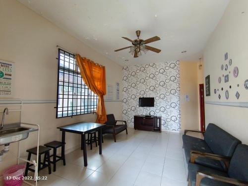 a living room with a ceiling fan and a table at Seaview Promenade Homestay Dungun in Dungun