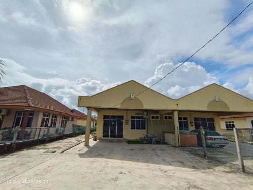 a yellow house with a fence in front of it at Seaview Promenade Homestay Dungun in Dungun
