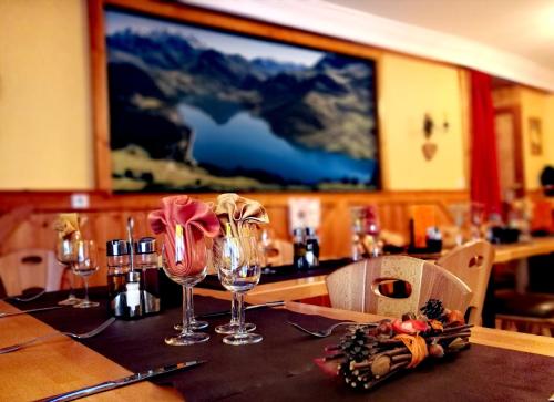 a table in a restaurant with wine glasses on it at Hôtel du Grand-Mont in Beaufort