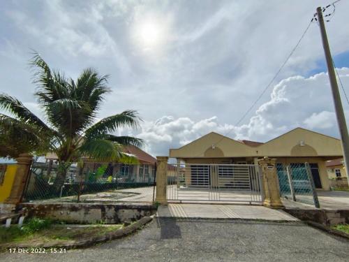 a house with a gate and a palm tree at Seaview Promenade Homestay Dungun in Dungun