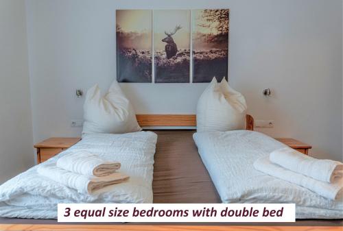 a bedroom with two beds with pillows and a picture on the wall at Haus Heimat Wagrain in Wagrain