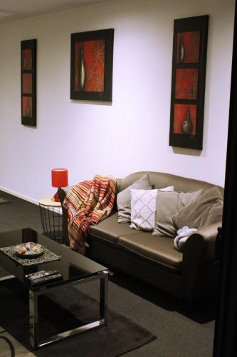 a living room with a couch and a table at Perfectly Located Modern Apartment - Canberra CBD in Canberra