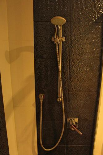 a shower with a hose attached to a wall at Perfectly Located Modern Apartment - Canberra CBD in Canberra
