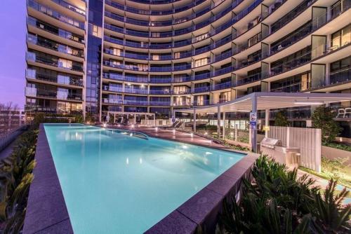 a large swimming pool in front of a large building at Perfectly Located Modern Apartment - Canberra CBD in Canberra