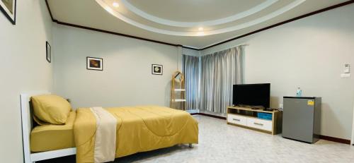 a bedroom with a bed and a tv in a room at Panutsaya Homestay in Wang Nam Khieo