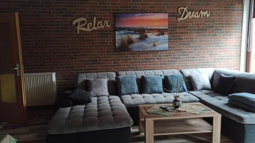 a living room with a couch and a brick wall at Nordlicht in Schortens