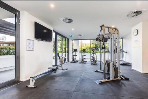 a gym with several tread machines in a room at Spacious & Open 2 bd 2bth 2crsp apt - Dickson CBD in Canberra