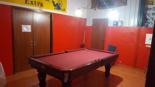 a pool table in a room with red walls at Bungalows Land'shause in Pataias