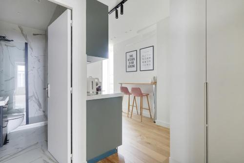 eine Küche mit weißen Wänden und blauen Schränken in der Unterkunft Pick A Flat's Apartments in Opéra - Rue d'Hauteville in Paris