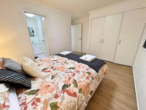 a bedroom with a bed with a floral bedspread at Beautiful & enclosed, 1 bd 1 bth - close to CBR Hospital in Phillip