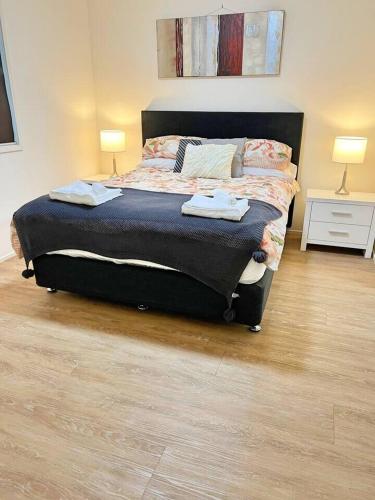 a bedroom with a bed with two lamps on it at Beautiful & enclosed, 1 bd 1 bth - close to CBR Hospital in Phillip