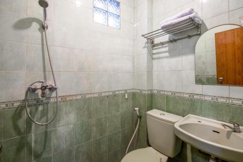 uma casa de banho com um chuveiro, um WC e um lavatório. em Hotel Ardellia em Bandung