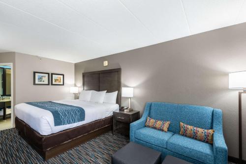 ein Hotelzimmer mit einem Bett und einem blauen Stuhl in der Unterkunft Comfort Inn Chicago Schaumburg - O'Hare Airport in Schaumburg