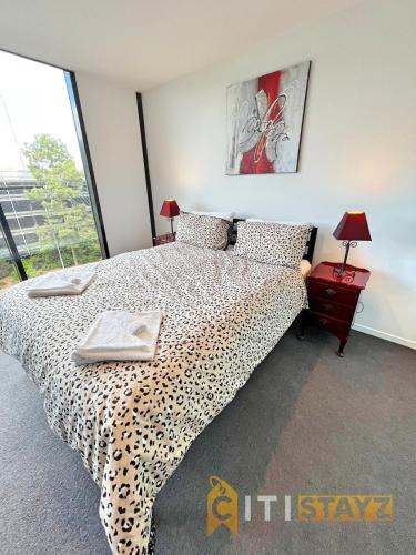 een slaapkamer met een bed met luipaardprint en een raam bij Enchanting in Red - 1bd 1bth 1csp in Canberra