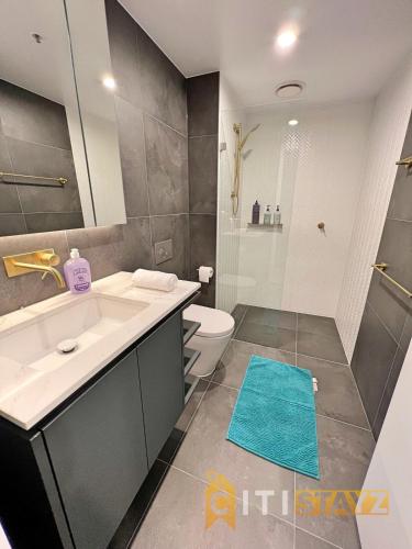 a bathroom with a sink and a toilet and a shower at Enchanting in Red - 1bd 1bth 1csp in Canberra