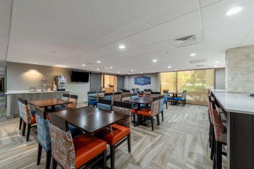 a restaurant with tables and chairs and a kitchen at Comfort Inn Chicago Schaumburg - O'Hare Airport in Schaumburg