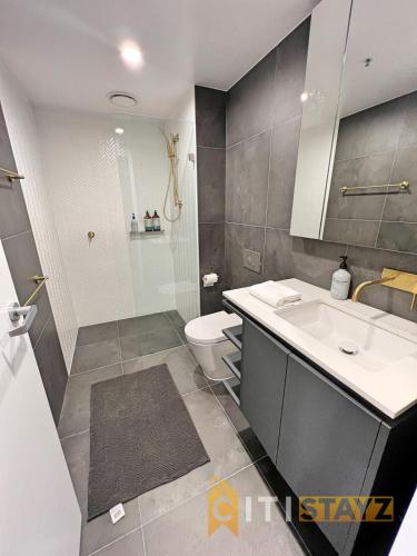 a bathroom with a sink and a toilet and a shower at Beauty in Blue! 1bd 1bth 1crsp Apt - Great Location! in Canberra