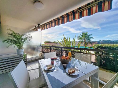 une table avec des assiettes de nourriture au sommet d'un balcon dans l'établissement Nestor&Jeeves - GRAND SUD TERRASSE - Pool - Free parking, à Nice