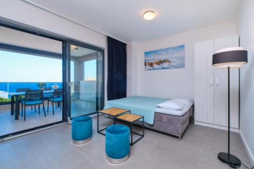 a bedroom with a bed and a table and a dining room at House Torre Apartments in Mali Lošinj