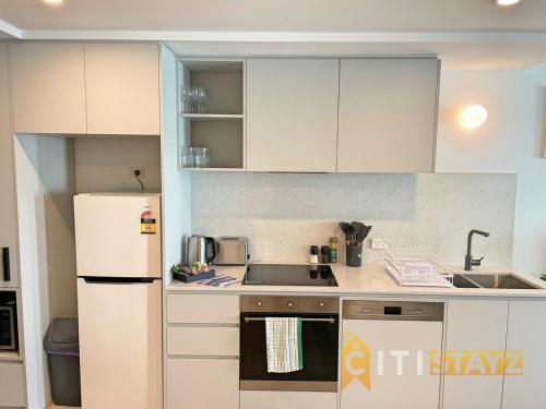 a kitchen with white cabinets and a white refrigerator at Splendid 2bd 1bth 1csp Apt - Superb CBD Location in Canberra