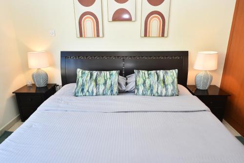 1 dormitorio con 1 cama grande y 2 lámparas en Lovely 1 Bedroom Apartment in Greens - ADN, en Dubái