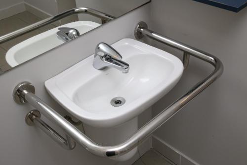 a bathroom with a white sink and a mirror at Delphin Surf Hotel in Guarujá