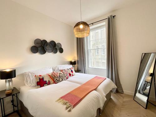 a bedroom with a large white bed with a window at Leith Street Suite in Edinburgh