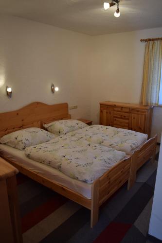 a bedroom with a large wooden bed in a room at Ski apartment St. Johann in Tirol, Kitzbuheler Alpen in Sankt Johann in Tirol