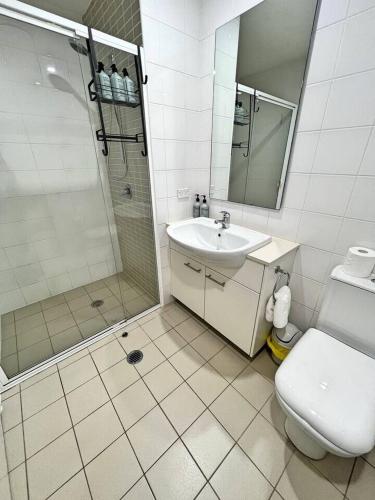 a bathroom with a sink and a shower and a toilet at Spacious & High in the Skyplaza - 1bd 1bth Apt in Phillip