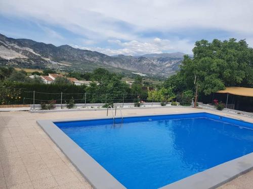 una gran piscina azul con montañas en el fondo en Casa rural en Padul entre Sierra Nevada y la Costa, en Granada