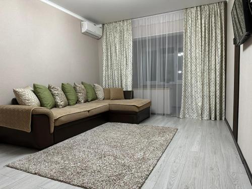 uma sala de estar com um sofá e um tapete em Двухкомнатная квартира em Shymkent