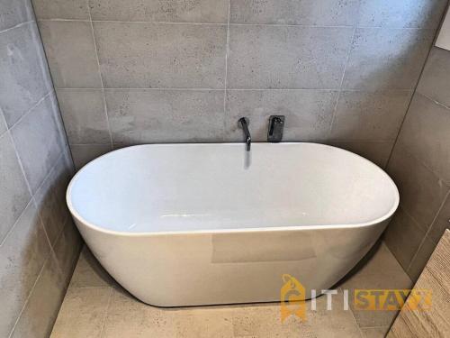 a white bath tub in a corner of a bathroom at Lavish in Lyons - 3bd 2bth Spacious & Modern Home in Lyons