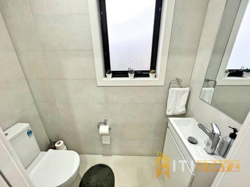 a bathroom with a toilet and a sink and a window at Lavish in Lyons - 3bd 2bth Spacious & Modern Home in Lyons