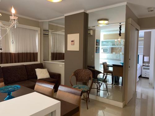 Una sala de estar con un sofá y un comedor. en Apartamento Ilhas do Sul, en Balneário Camboriú