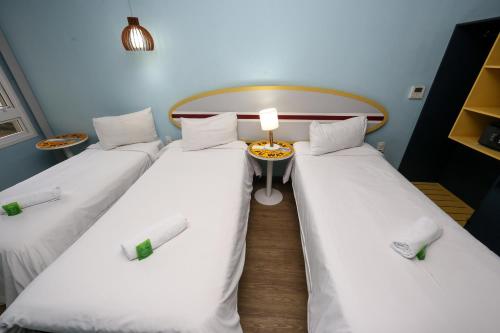a room with two twin beds and a table at Delphin Surf Hotel in Guarujá