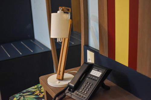 a phone sitting on a table next to a lamp at Delphin Surf Hotel in Guarujá