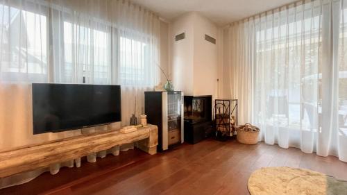 sala de estar con TV de pantalla plana grande en Ian's Residence, en Kranjska Gora