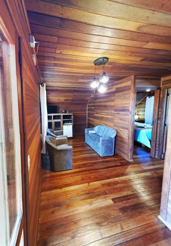 a room with wooden floors and a room with a bed at Pousada Vereda do Sol in Cambara do Sul