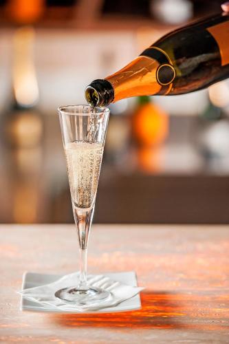 a bottle of champagne being poured into a glass at Brut by Slaviero Hotéis in Balneário Camboriú