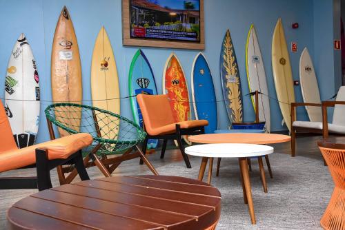 a bunch of surfboards are lined up against a wall at Delphin Surf Hotel in Guarujá