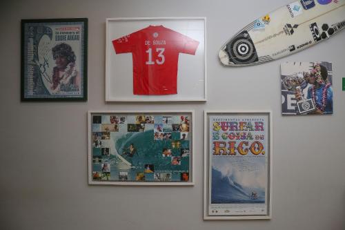 a wall with photos and posters on a wall at Delphin Surf Hotel in Guarujá