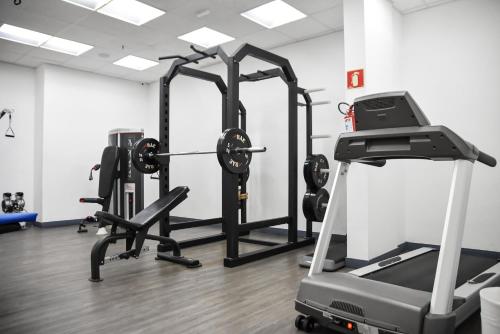 a gym with several tread machines and a treadmill at Delphin Surf Hotel in Guarujá