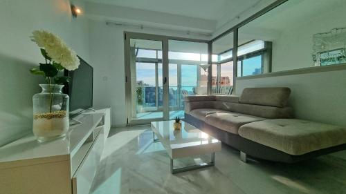a living room with a couch and a table at Large and sunny all-day balcony with stunning sea views in Benidorm
