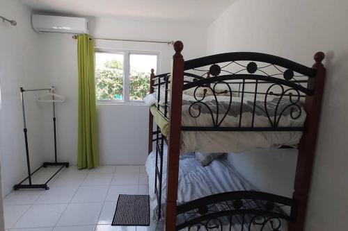 a bedroom with a metal bed with a window at Casa Aichi in Willemstad